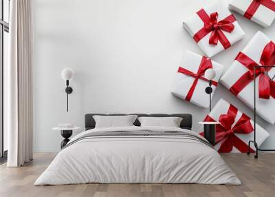 Five neatly wrapped white presents decorated with red bows are arranged on a plain white background, creating an elegant and minimalistic composition. Wall mural