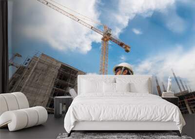 Civil engineer checking work with  construction drawing at building site of highrise building Wall mural