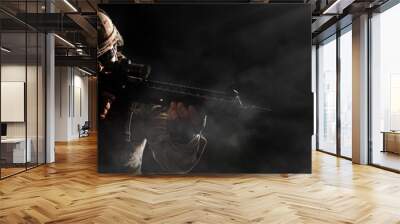 US Army soldier in combat uniforms holding machine gun ready to attack in smoke around on dark background. Silhouette soldier, Veterans Day, Patriot concept in banner size Wall mural