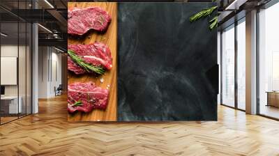 fresh raw meat on chopping board with rosemary. top-view Wall mural