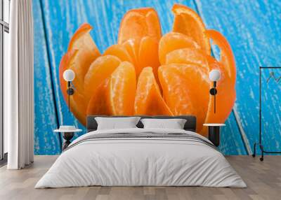 one peeled tangerine on a blue wooden background Wall mural