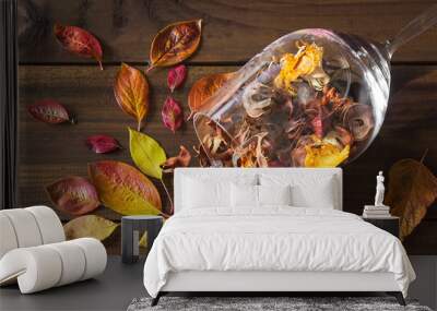 Autumn leaves in a wine glass on wooden table background Wall mural