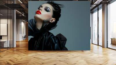 A fashion model in avant-garde clothing, standing in a striking pose with bold makeup, set against a stark, minimalist studio background with dramatic lighting Wall mural