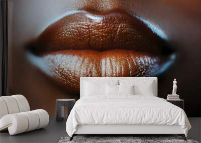 Close-up of full, glossy African lips, rich brown tone with vibrant lipstick, reflecting a soft light, set against a blurred background Wall mural