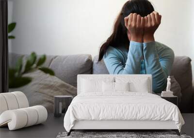 Depressed woman sit alone on the sofa at home with stress sad upset Wall mural