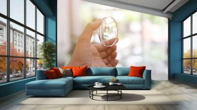 Hand holding lens eyeglasses  Wall mural