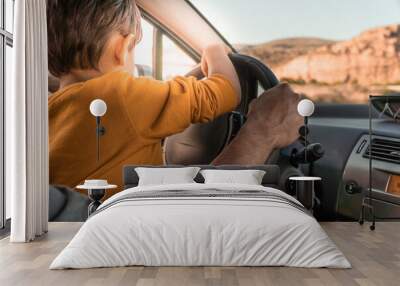 father teaching his little son to drive. playing driver in daddy's car. Father's day. parenting concept Wall mural