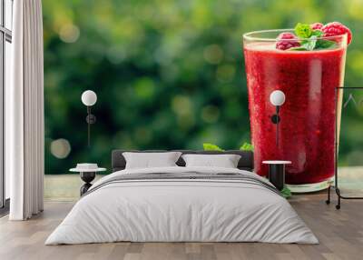 Healthy raspberry smoothie on rustic wooden board, served outside in green summer garden Wall mural