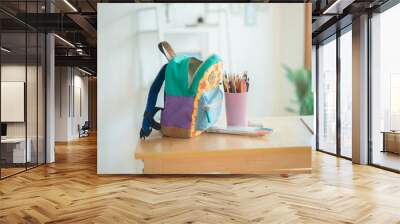 School backpack on wooden bench and home in the background Wall mural