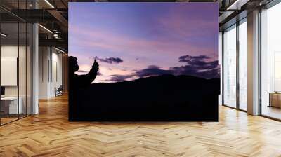 Man with arms extended toward heaven at sunrise ,success or prayer concept Wall mural