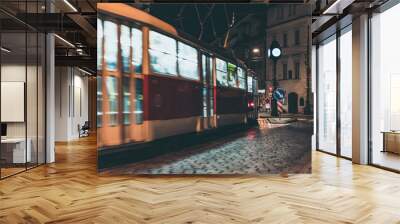 red tram in motion on city street at night Wall mural