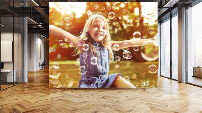 Cute little girl playing soap bubbles Wall mural