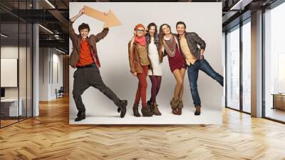 Young man pointing at group of friends Wall mural