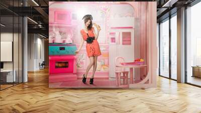 Young woman like a doll cokking in pink kitchen Wall mural