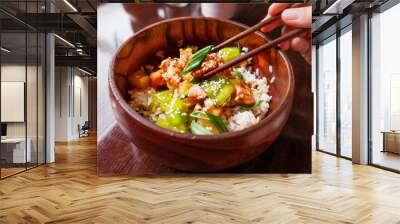 Asian cuisine - rice in sauce with stir fried vegetables, pineapple and salmon. Wooden bowl with chopsticks.  Wall mural