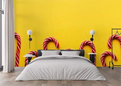 Banner with Christmas candy cones on yellow background. Colorful holiday sweets with bright copy space. Traditional dessert wtih red and white stripes. Wall mural