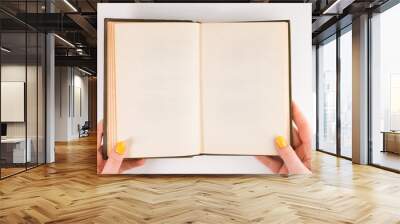 A woman (female) two hands hold an empty (blank) book spread isolated on white background, flat lay Wall mural