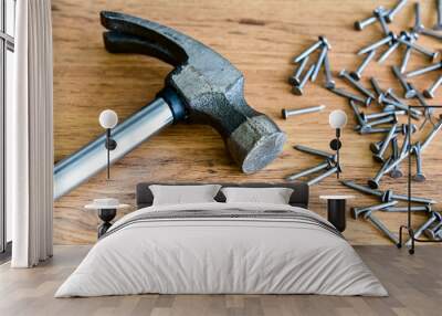 Metal hammer with nails on a wooden table. Close up. Carpenter concept Wall mural