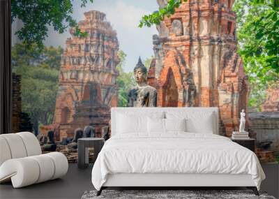 Only intact ancient Buddha statue among the destroyed statues in Ayutthaya historical park, Thailand. Wall mural