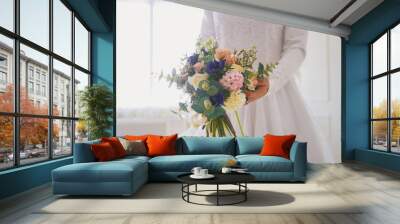 Hands of muslim bride in white dress holding the bouquet of flowers Wall mural