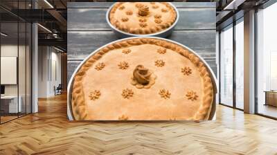 Two potato pies with edible decorations on top standing on the wooden table Wall mural