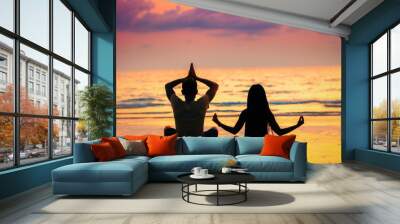 yoga or meditation concept background, silhouette loving couple people on the beach at sunset Wall mural