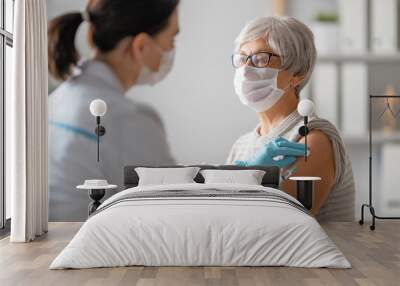 Doctor giving a senior woman vaccination Wall mural