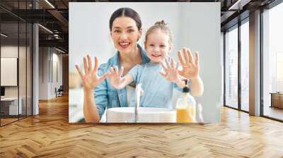 girl and her mother are washing hands Wall mural