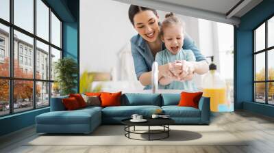 girl and her mother are washing hands Wall mural