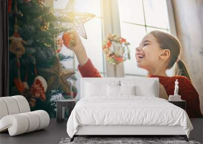 girl is decorating Christmas tree Wall mural