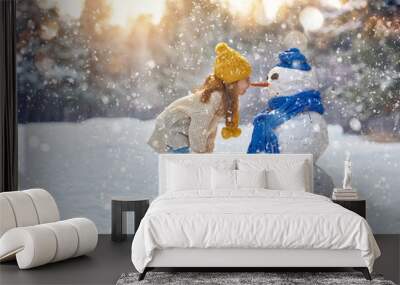 girl playing with a snowman Wall mural