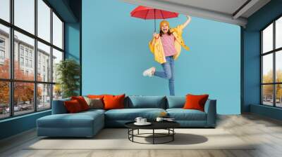 Kid with umbrella on colored background. Wall mural