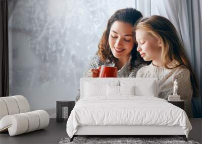 Mother and daughter enjoying winter nature in the  window Wall mural