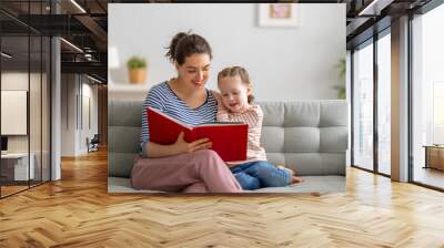 mother reading a book to daughter Wall mural