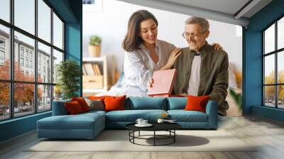 woman congratulating father and giving  him a gift Wall mural