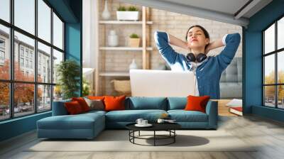 woman working on a laptop at home. Wall mural