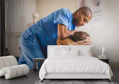 A Chiropractor treating a young boy Wall mural