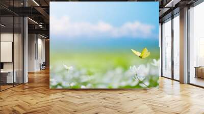 Art Beautiful blurred spring background nature with blooming glade, butterfly and blue sky on a sunny day Wall mural