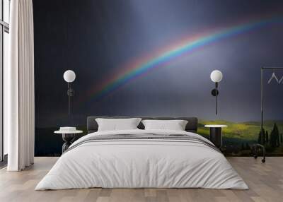 Rain, sunbeams and Rainbow in dramatic dark sky over green hillside;  beautiful summer countryside landscape Wall mural