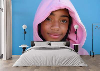 A young woman wearing a pink hoodie with her eyes closed Wall mural