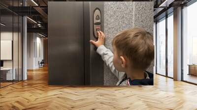 The little boy is calling the elevator. Wall mural