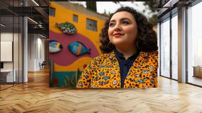 Woman in colorful jacket smiling in front of vibrant wall art mural Wall mural