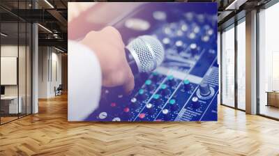 Microphone in hand and adjust an audio mixer controller in the control room Wall mural