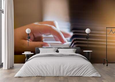 Selective focus of kid fingers and  piano key to play the piano with lighting. Wall mural