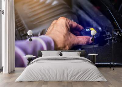 Selective focus to The mechanic's hand is opening the cap to check the brake fluid in the car engine room. Wall mural