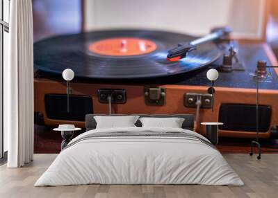 Selective focus to vintage record player on a table in a music studio playing an old vinyl album. Close-up image of a vintage record player for vinyl. Wall mural