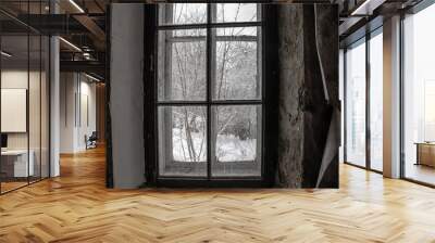 View through an old window in an abandoned house. Snowy trees outside the window. Shabby walls of an abandoned house Wall mural