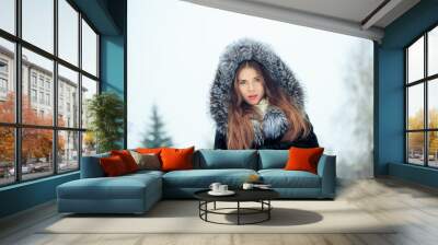 beautiful smiling girl on background of snowy trees. Winter portrait. coat with a hood Wall mural