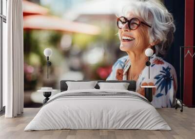 Photo of a beautiful happy elderly woman wearing glasses against the backdrop of beautiful mountains Wall mural