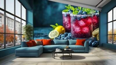 Three glasses of blueberry juice with ice and lemon slices on a table Wall mural